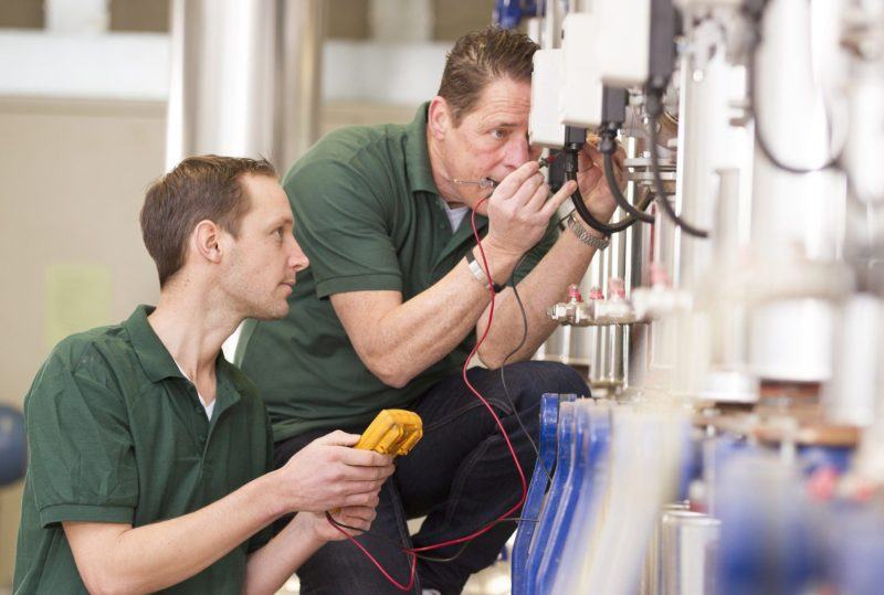 two male technicians work on thermal technology high temperature furnace